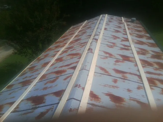 Rusted metal roof panels with new wood purlins before replacement — Storm Damage Roof Repair in Halethorpe by Roofing Brothers