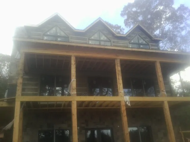 Dormers and porch framing on a large log home under construction — Roof Coating work by our crew in Halethorpe