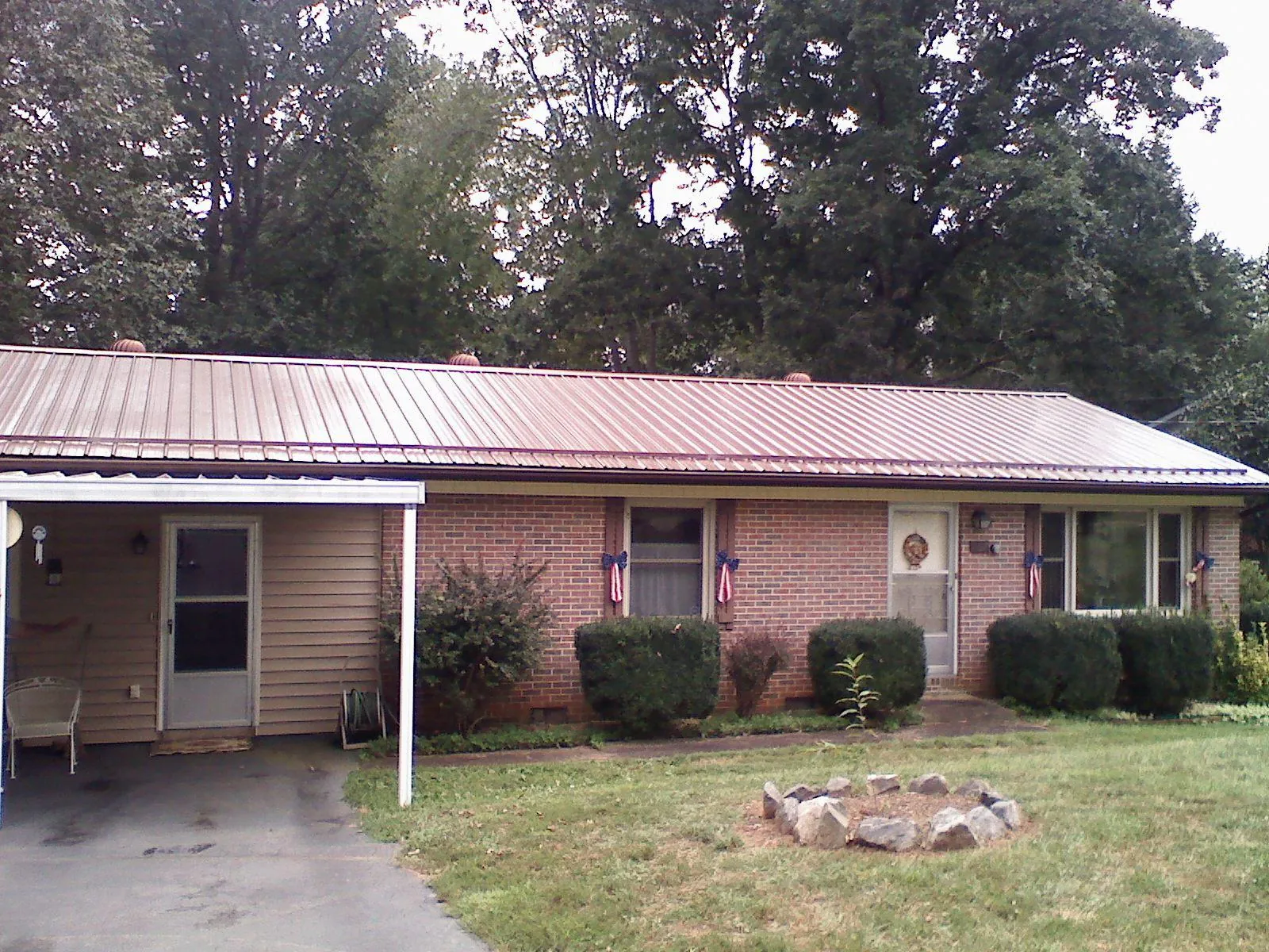 Bronze metal roof and carport on a brick ranch home — Roof Repair work by our crew in Halethorpe