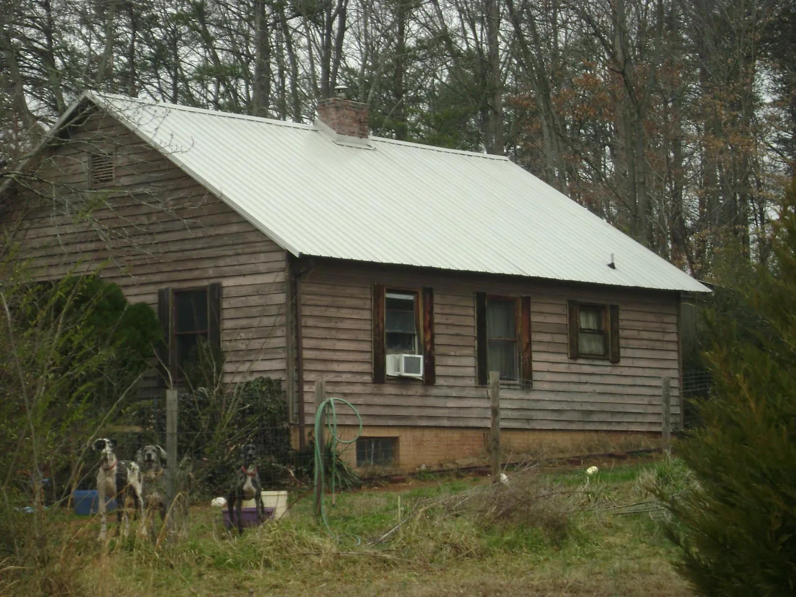 White metal roof on an old wood sided farmhouse, from a Metal Roof Installation job in Halethorpe